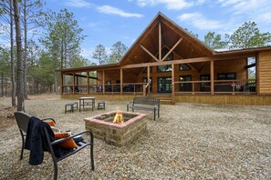 Enjoy surround seating by the backyard fire pit just off the expansive back deck at The Conifer Cabin. Another propane fireplace is available for use on the covered back deck.