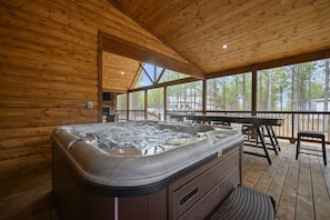 Dip in the hot tub and enjoy the privacy and coverage on the back deck. The Conifer Cabin has an expansive covered back deck loaded with amenities including shuffleboard, corn hole, putting green, and more!