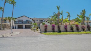 Shell House Getaway is on the right side of the duplex. The pool is behind the flowered wall.