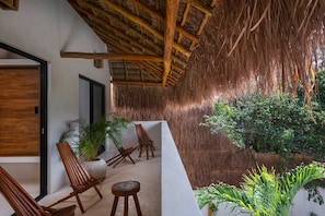Private balcony shared by two second-floor rooms. They are covered by a typical palapa roof. Wooden chairs for enjoying the space.
