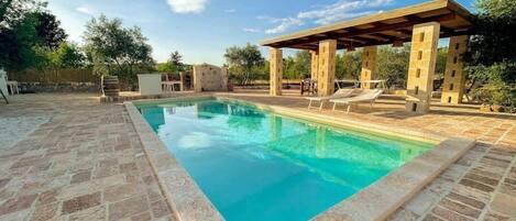 Piscina con zona pranzo all'aperto coperta