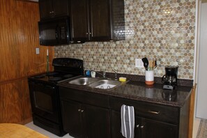 Kitchen w/ fridge, stove, oven microwave and toaster.