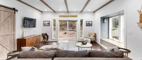 Bright and cool living area with a large couch and a view of the outside.
