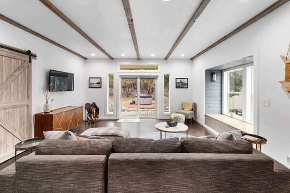 Bright and cool living area with a large couch and a view of the outside.