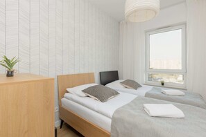 A minimalist bedroom featuring a double bed, textured wallpaper, and soft lighting.
