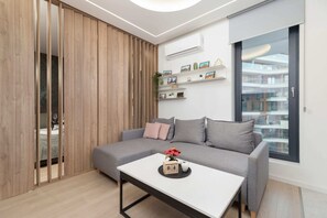 A modern living room with a comfortable sofa, a coffee table, and built-in shelving with decorative lighting.
