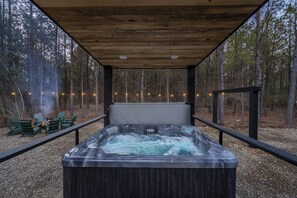 "Unwind in the covered hot tub, surrounded by high-end outdoor furniture, blending comfort with the beauty of nature."