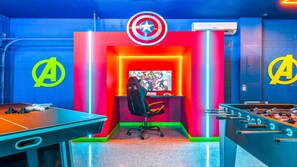 Avengers-inspired game room with neon lighting, gaming setup, and fun table games.