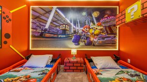 Mario Kart-inspired bedroom with race car beds, vibrant wall art, and playful details.