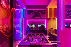 This vibrant and electrifying space features cutting - edge gaming stations and a foosball table, perfect for gamers looking for a thrilling and immersive environment.