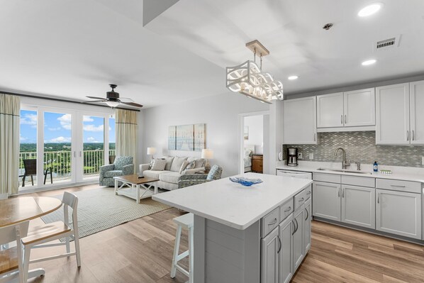 Open Concept Living Room with Sleeper Sofa, Flat Screen TV, Lake Views and Direct Balcony Access plus Open-Concept Fully Equipped Kitchen with Drip Coffee Maker