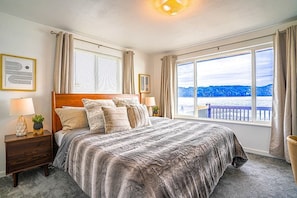 Indulge in the luxury of our master bedroom, featuring a sumptuous king-sized bed and an expansive water view that will take your breath away