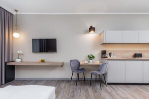 A workspace and kitchenette featuring a small table, chair, and modern decor.
