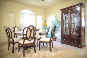 A sun-drenched dining area with a classy table and chairs