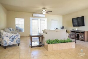 The sitting area features comfy seating and a wall-mounted Smart TV