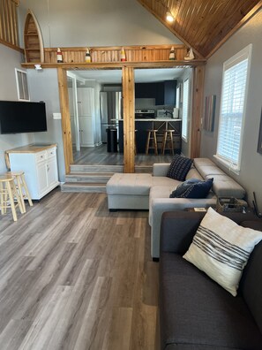 Living room view from deck entry; open steps to loft on left. 