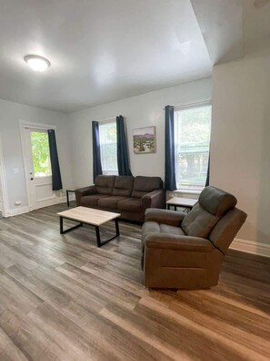 Relax in this cozy living room with comfortable couches, a flat-screen TV, and a coffee table. Enjoy over 145 channels with DirecTV for endless entertainment and relaxation.