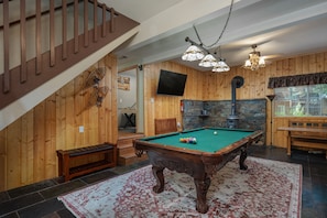 Pool room with plenty of seating, smart tv and fireplace. 