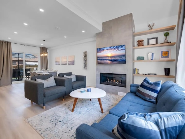 Open concept living room with vaulted ceiling, gas fireplace and smart TV