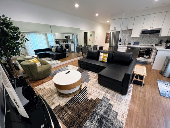 Living room with mirrored wall. Roller shades on the mirror to cover as needed.