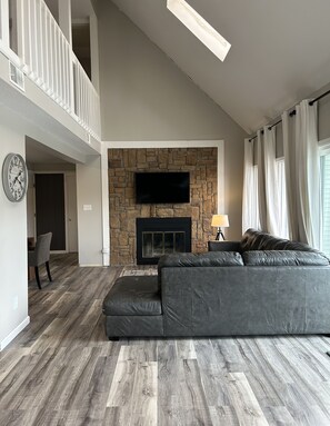 Living area with sectional, smart tv and fireplace.