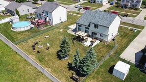 Spacious Fenced in backyard with a Firepit, Pergola, BBQ, and plenty of seating for all.