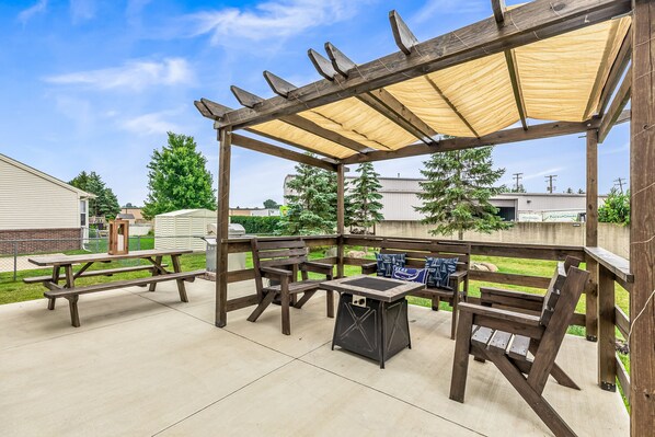 Outdoor living space offers covered pergola & picnic seating. Enjoy the gas fireplace, BBQ grill, and extra seating on the picnic table.