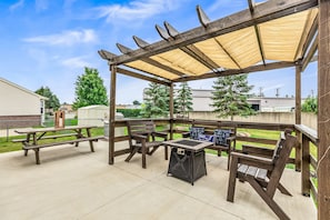 Outdoor living space offers covered pergola & picnic seating. Enjoy the gas fireplace, BBQ grill, and extra seating on the picnic table.