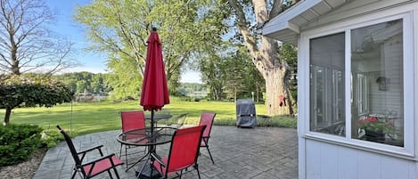 Stamped concrete patio with a grill and outdoor dining space complete with views of Lake Allegan