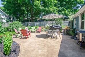 Patio with BBQ grill, outdoor table, and relaxing chairs
