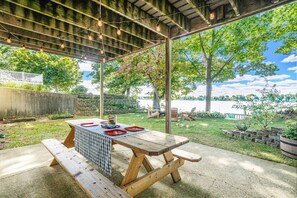 Patio on the lawn with picnic table and fairy lights