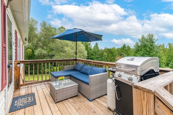 A relaxing balcony/patio with a BBQ grill, perfect for outdoor dining and enjoying the view.