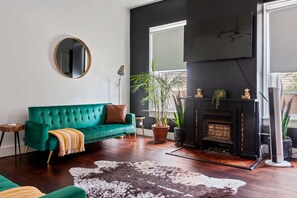 Discover the Charm of Our Jungle House Airbnb - Stylish Living Room with Modern Decor! Round Mirror & Gold Accents 😁🛋️