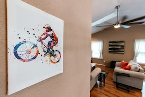 Vibrant cyclist artwork adding a splash of color to a cozy, warmly lit living room.