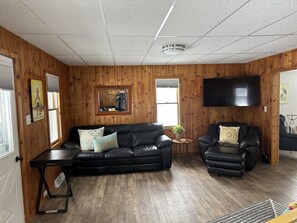 Large open living room with multiple comfy seating options and a 55" T.V. 