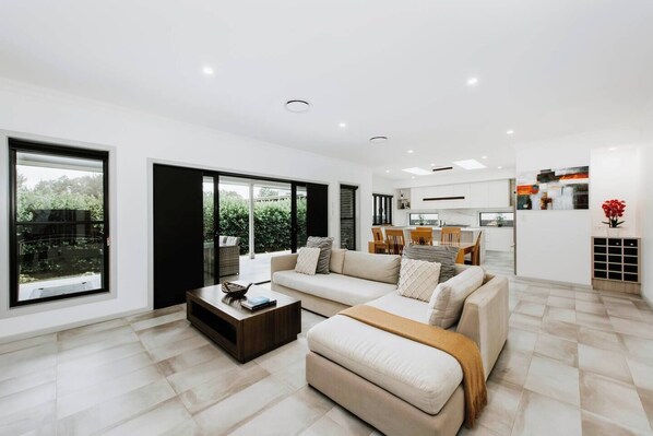 The spacious lounge area seamlessly flows out to the undercover patio and grassy backyard.