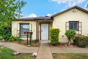 Charming home with cozy vibes, lush landscaping, and a welcoming entrance.