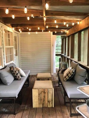 One of two fully screened in porches overlooking the forest. This one is downstairs off the south bedroom. It features an outdoor shower and two day beds.