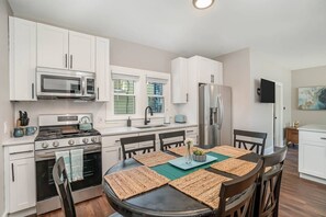 Downstairs unit fully stocked kitchen with seating for 6 at kitchen table, and an additional two at breakfast bar.