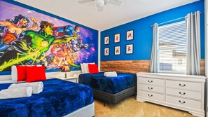 Bold superhero-themed room with twin beds and vibrant comic-style wall art.
