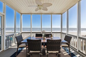 Screened in porch with access to the dining room, that includes a dining table with seating for six.