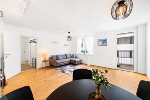 View from the dining area towards the couch and the balcony door.