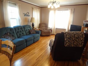 Living room with 2 recliners and a reclining couch. Roku TV