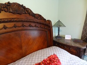 Bedroom with queen bed and stone top end table