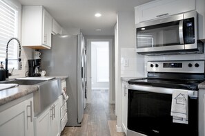 Chic kitchen with white cabinets, stone tops & natural light