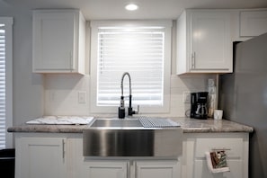 Chic kitchen with white cabinets, stone tops & natural light