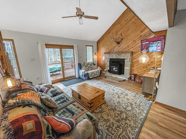 Spacious living room with pellet stove, Roku TV, comfy seating & door to deck.