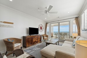 Living room with TV and adjoining porch with ocean view