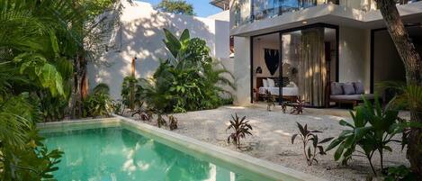 Patio with incredible vegetation and a large pool.