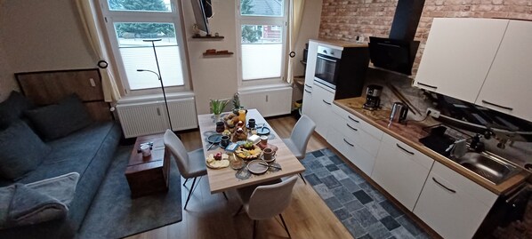 Wohnbereich mit offener Küche, Kamin und höhenverstellbarem TV